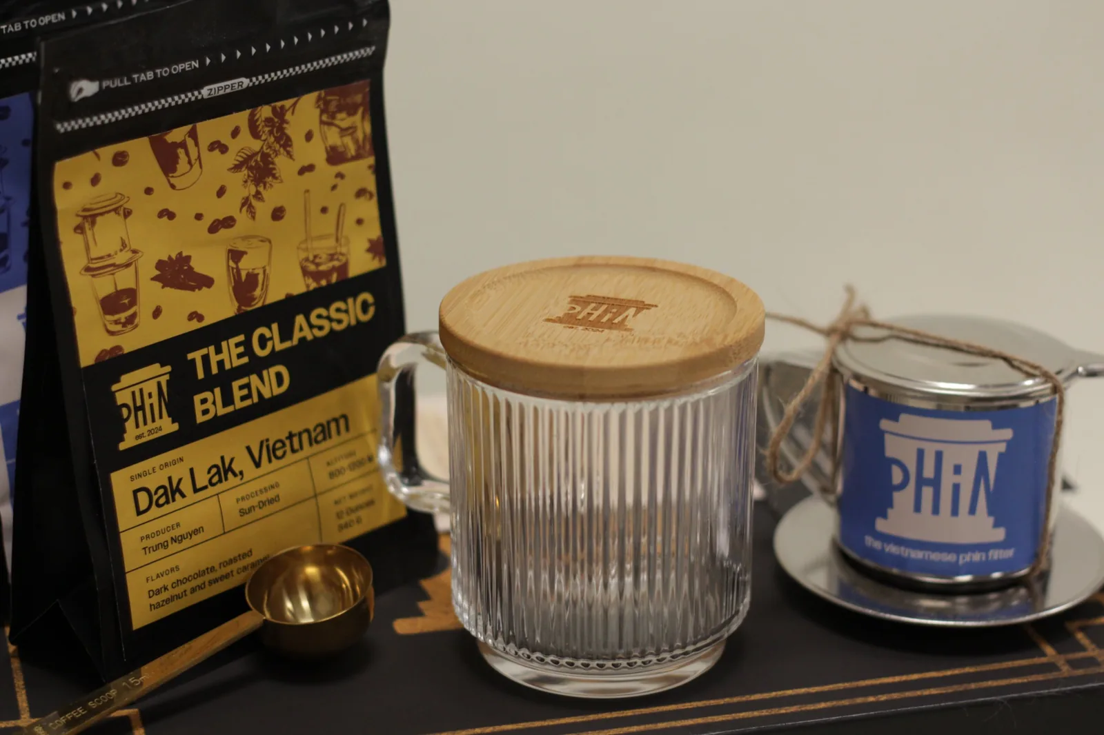 The Classic Blend bag next to a glass mug with an engraved bamboo lid